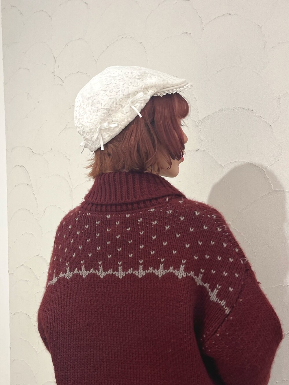 レッド系のカーディガン/ボレロ、グレー系のスカート、ブラック系のブーツを着用したレディースの秋コーディネートの7枚目の写真