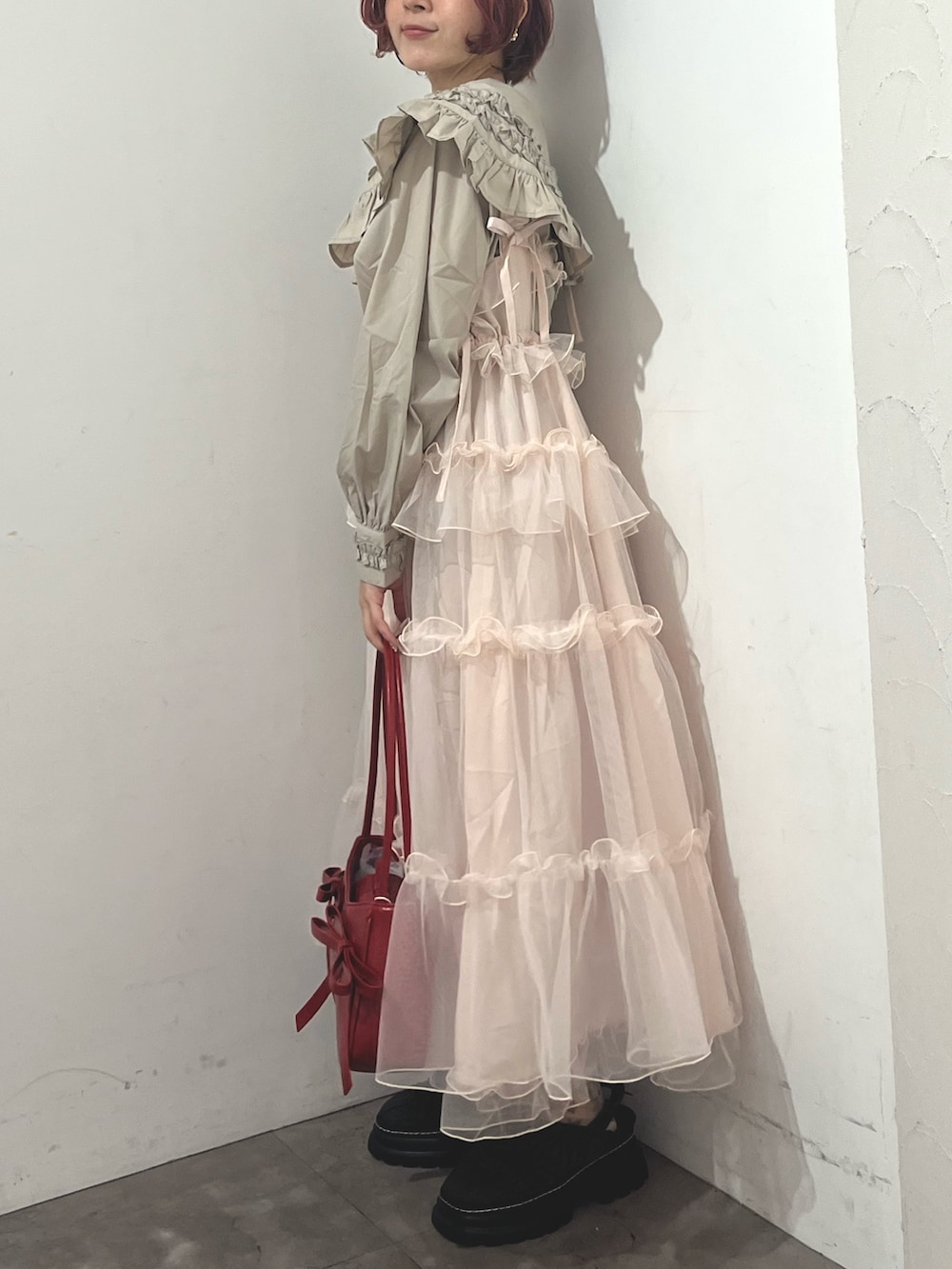 ベージュ系のシャツ/ブラウス、ピンク系のワンピース、レッド系のハンドバッグを着用したレディースの秋コーディネートの3枚目の写真