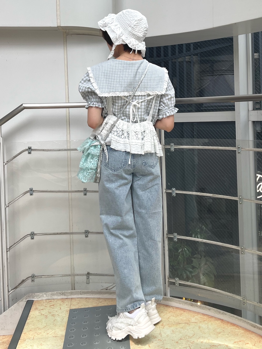 ホワイト系のキャミソール、グリーン系のシャツ/ブラウス、ブルー系のショルダーバッグを着用したレディースの春コーディネートの3枚目の写真