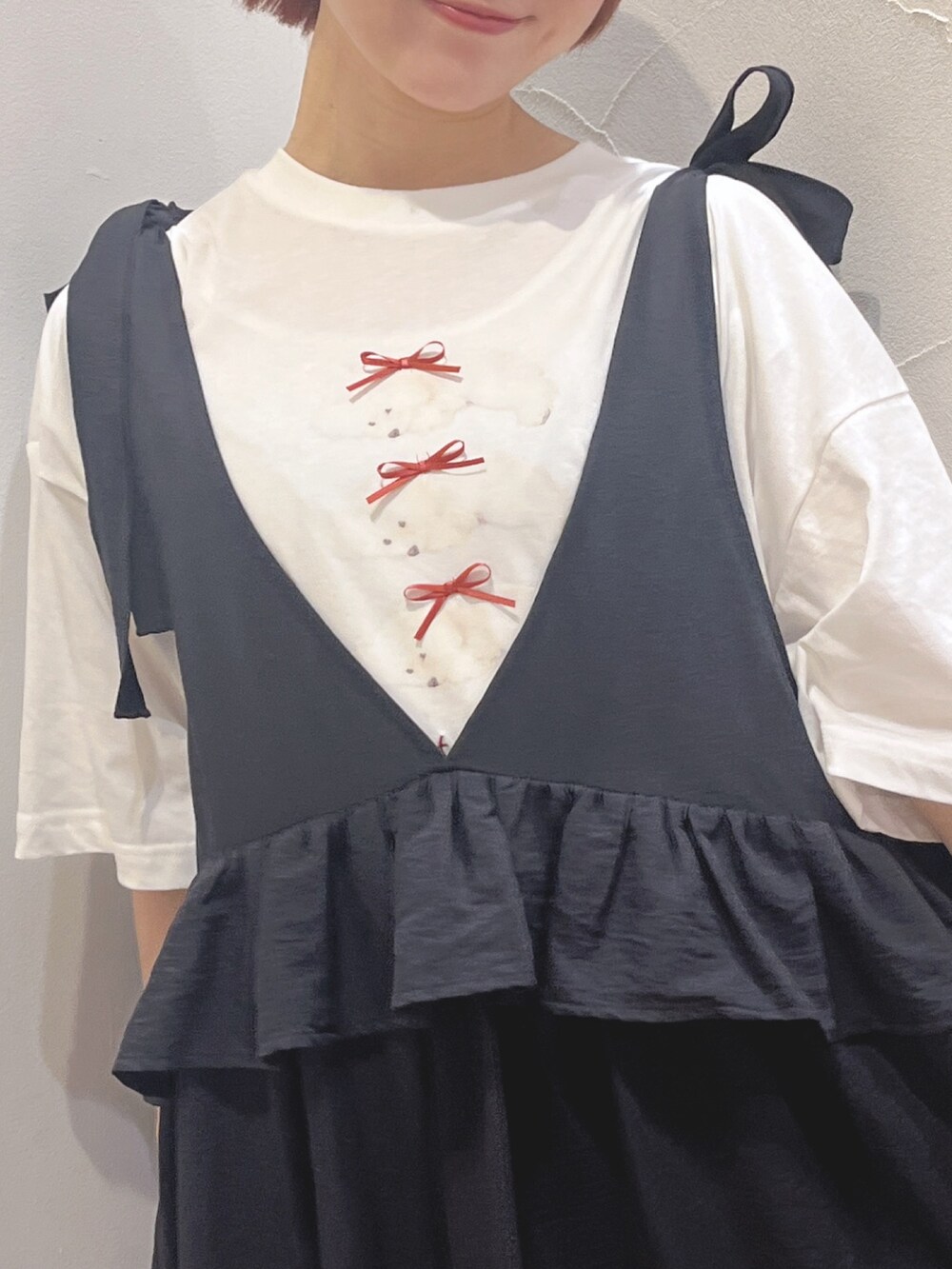 ブラック系のワンピース、ホワイト系のTシャツ/カットソー、ブラック系のサンダルを着用したレディースの春コーディネートの6枚目の写真