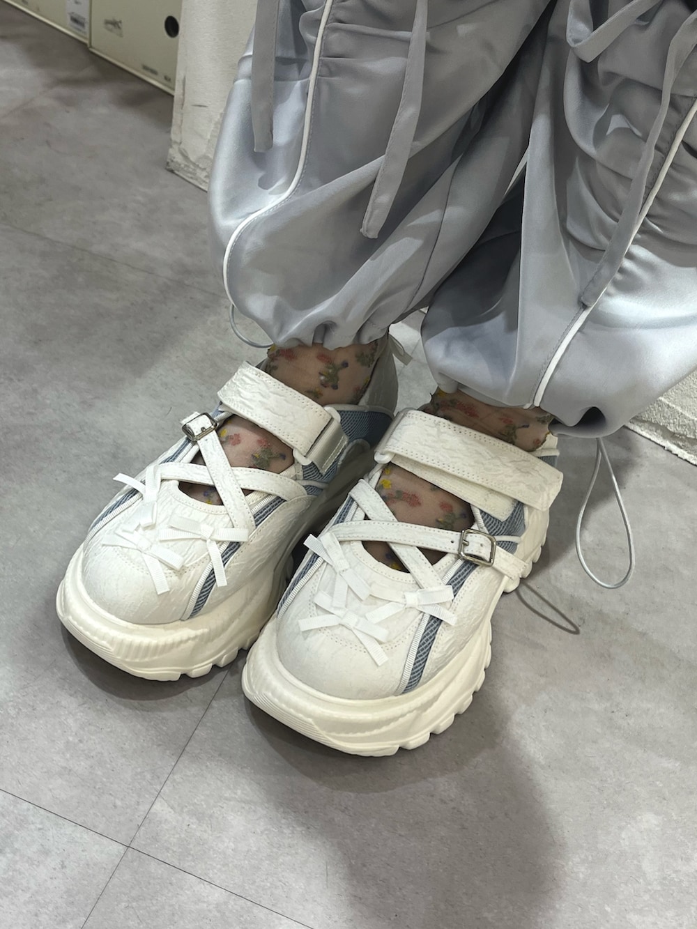 ブルー系のショルダーバッグ、グレー系のTシャツ/カットソー、ホワイト系のカーディガン/ボレロを着用したレディースの秋コーディネートの10枚目の写真