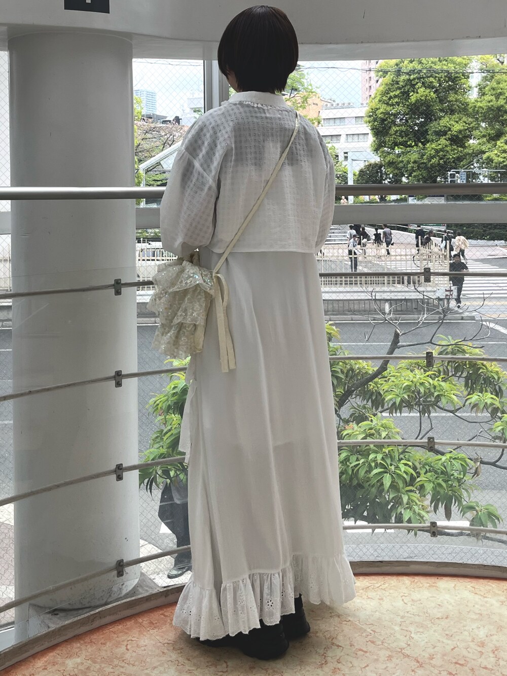 ブラック系のスニーカー、ブラック系のニット/セーター、ホワイト系のワンピースを着用したレディースの春コーディネートの3枚目の写真