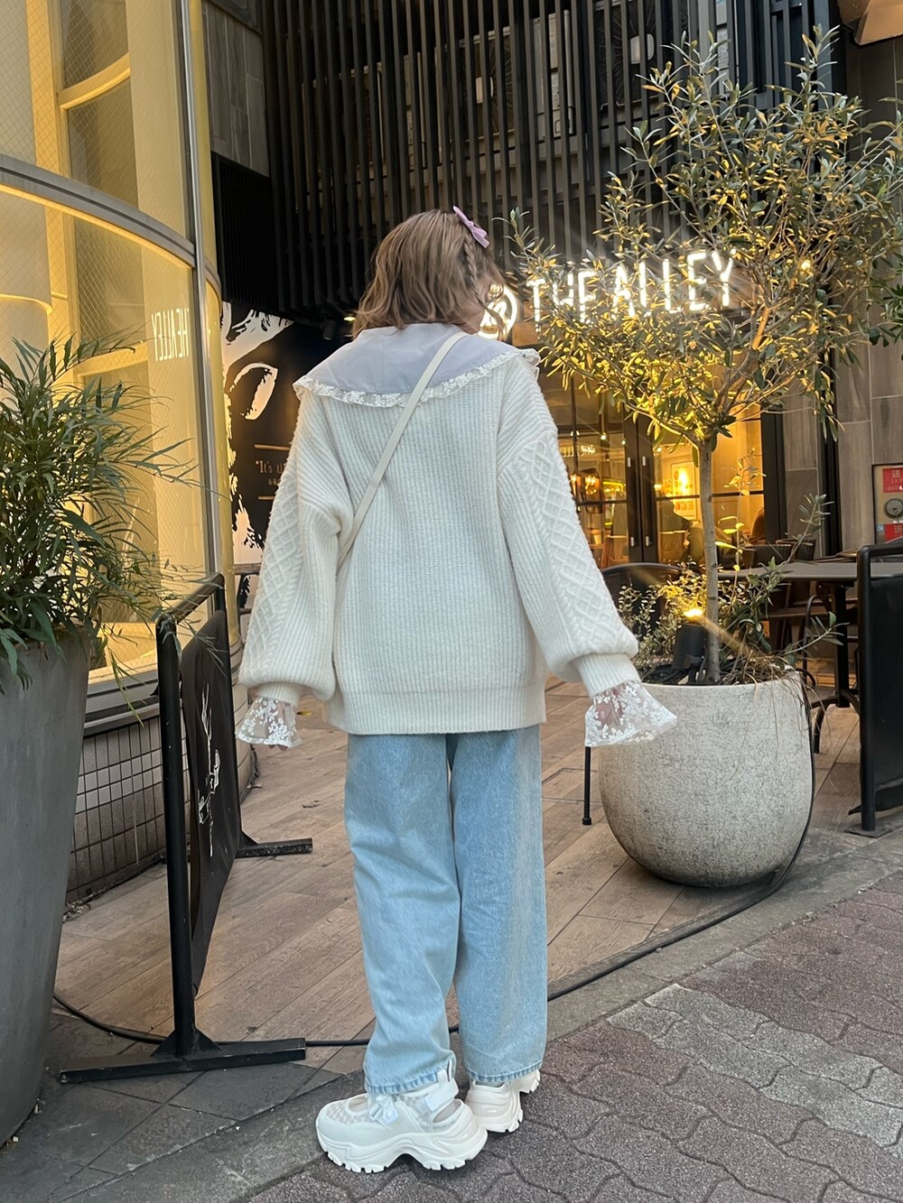 ホワイト系のショルダーバッグ、ホワイト系のニット/セーター、ブルー系のシャツ/ブラウスを着用したレディースの冬コーディネートの3枚目の写真