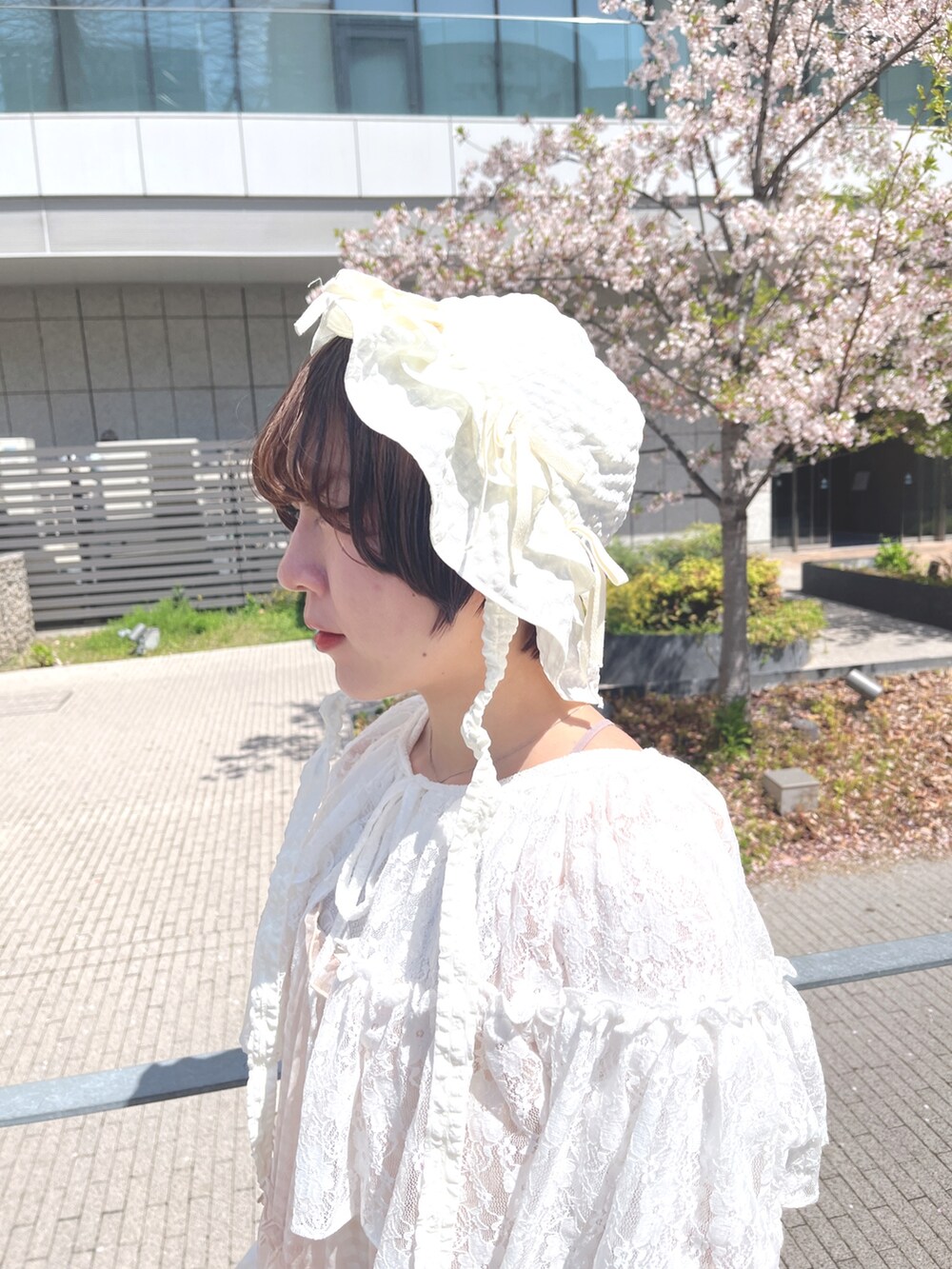 ベージュ系のワンピース、ホワイト系のカーディガン/ボレロ、ホワイト系のTシャツ/カットソーを着用したレディースの春コーディネートの7枚目の写真