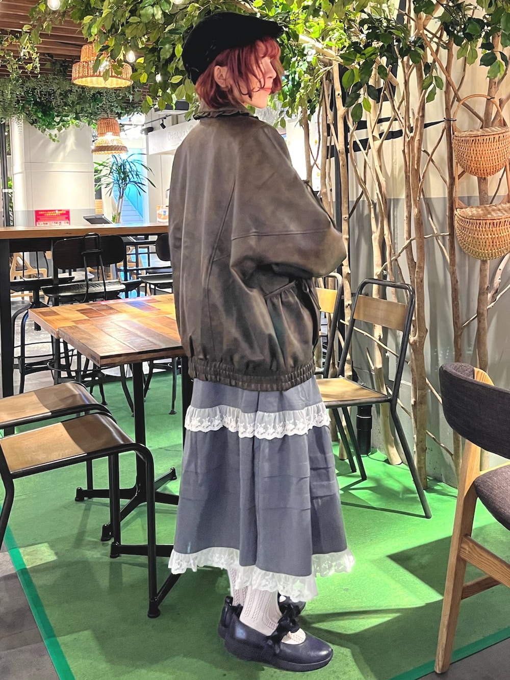 ブラウン系のブルゾン、ブルー系のニット/セーター、グレー系のスカートを着用したレディースの秋コーディネートの3枚目の写真