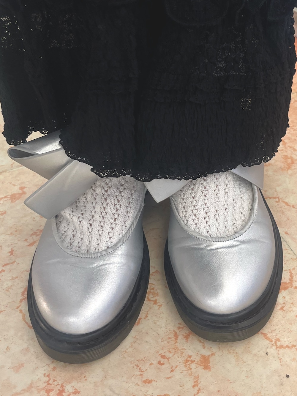 グレー系のニット/セーター、ブラック系のMA-1、ブラック系のスカートを着用したレディースの秋コーディネートの9枚目の写真