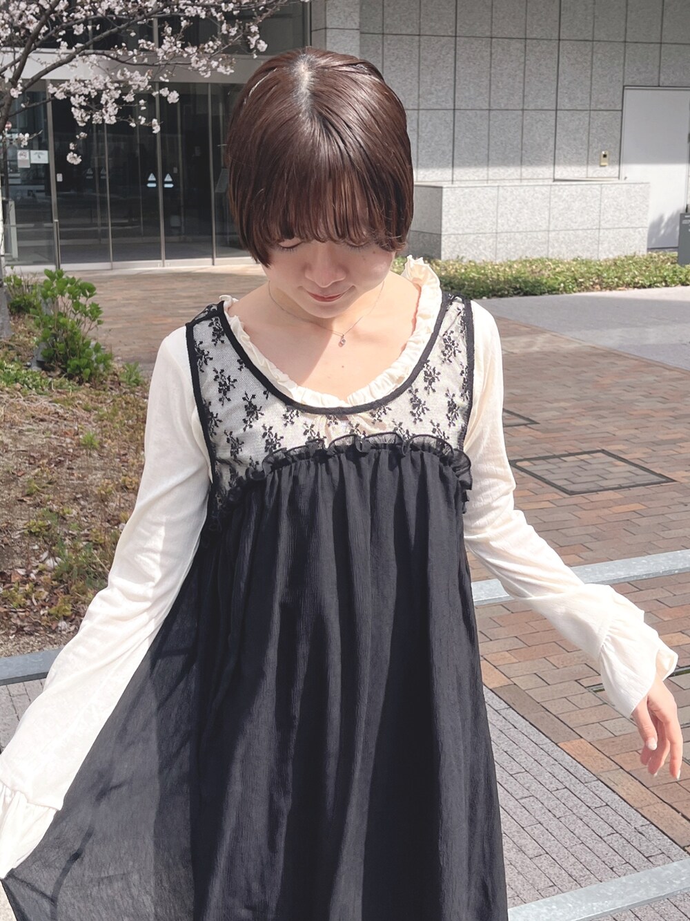 ホワイト系のTシャツ/カットソー、ブラック系のワンピース、ブラック系のスニーカーを着用したレディースの春コーディネートの5枚目の写真