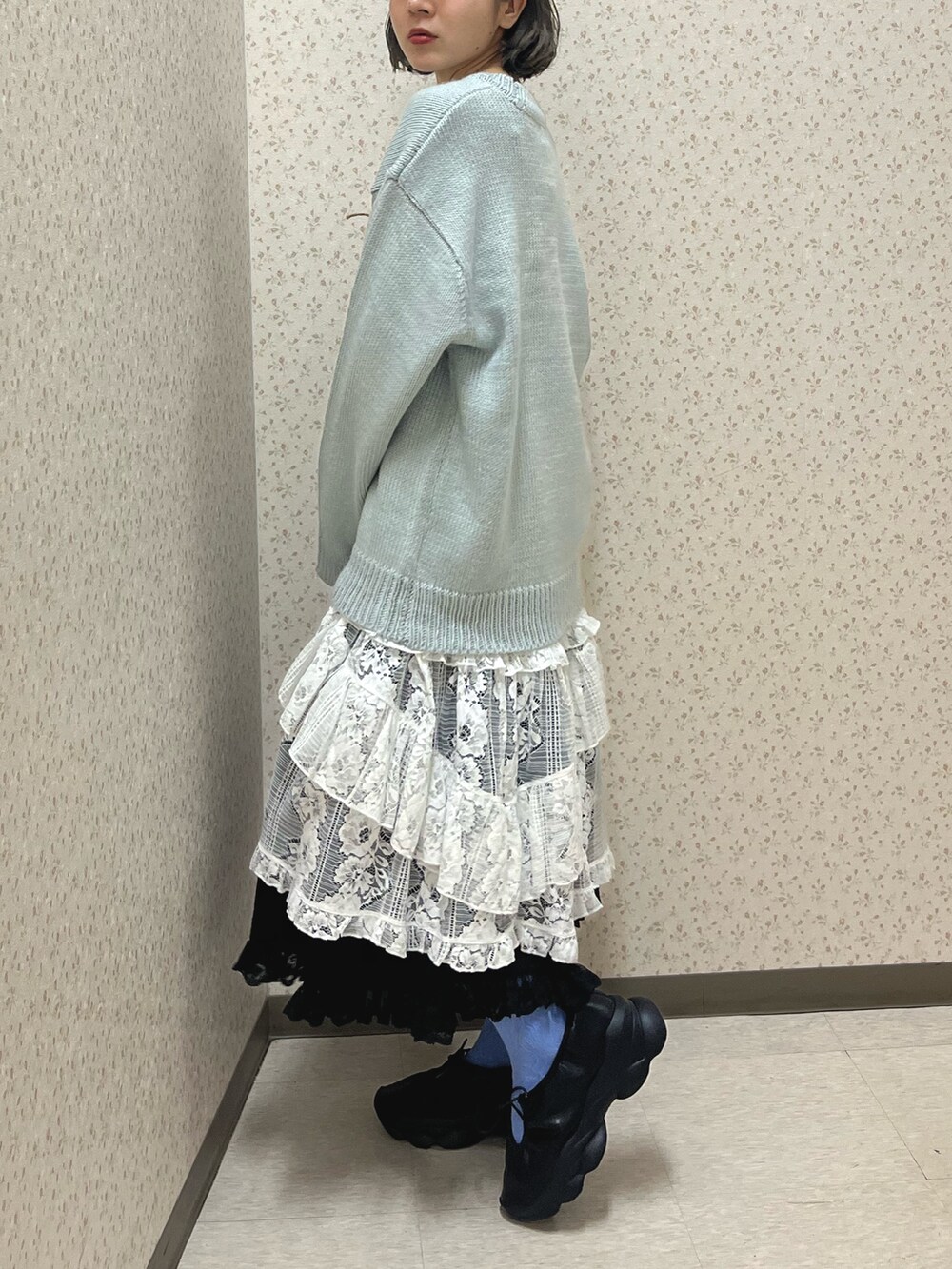 ブルー系のニット/セーター、ホワイト系のスカート、ブラック系のスカートを着用したレディースの秋コーディネートの4枚目の写真