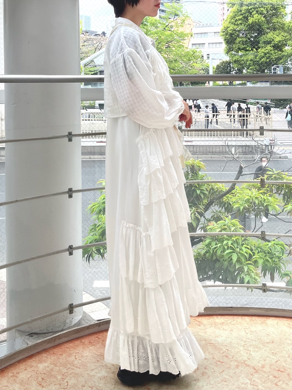 ブラック系のスニーカー、ブラック系のニット/セーター、ホワイト系のワンピースを着用したレディースの春コーディネートの2枚目の写真