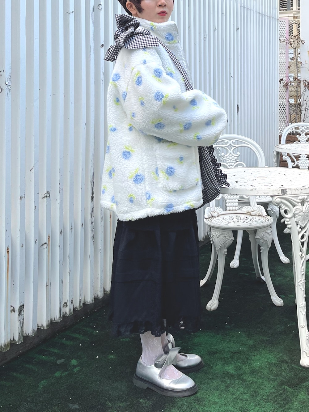 ブラック系のショルダーバッグ、ブルー系のニット/セーター、ホワイト系のシャツ/ブラウスを着用したレディースの冬コーディネートの3枚目の写真