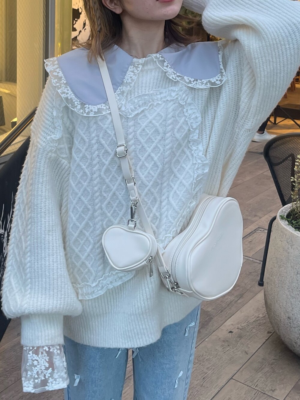 ホワイト系のショルダーバッグ、ホワイト系のニット/セーター、ブルー系のシャツ/ブラウスを着用したレディースの冬コーディネートの5枚目の写真