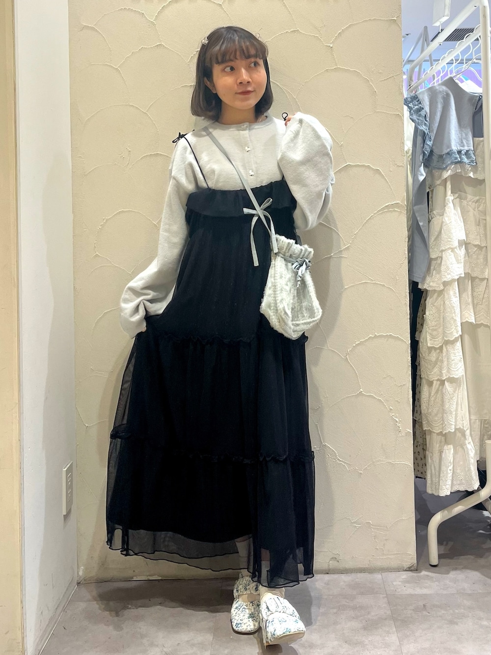 ブラック系のワンピース、ブルー系のショルダーバッグ、ホワイト系のパンプスを着用したレディースの春コーディネートの5枚目の写真