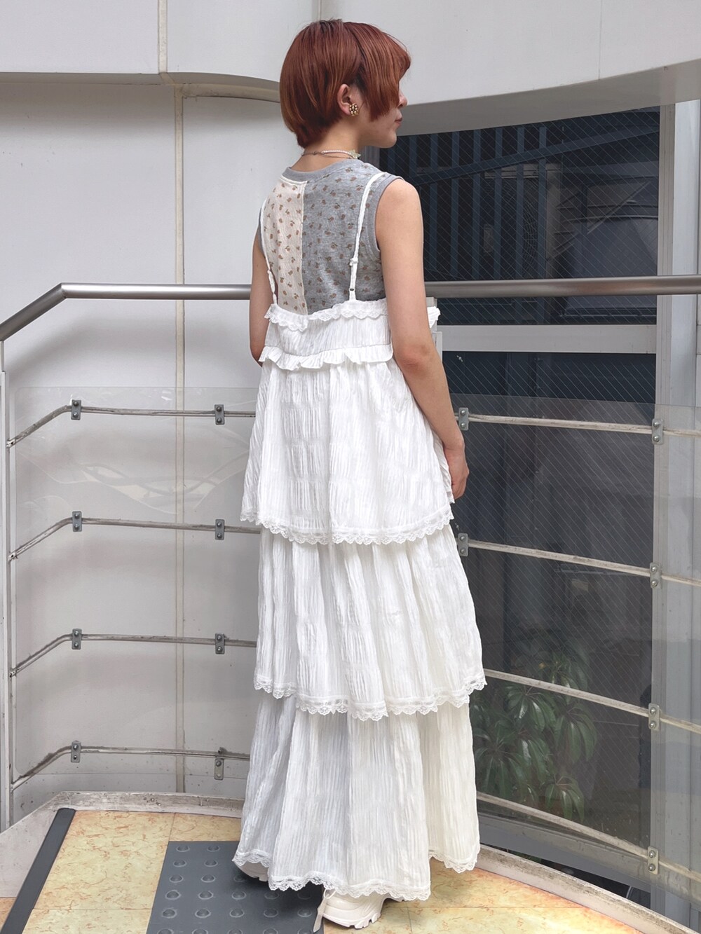 ホワイト系のワンピース、グレー系のタンクトップ、ホワイト系のスニーカーを着用したレディースの春コーディネートの3枚目の写真
