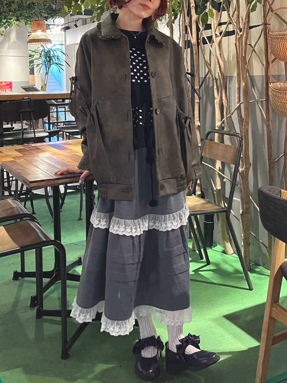 ブラウン系のブルゾン、ブルー系のニット/セーター、グレー系のスカートを着用したレディースの秋コーディネートの2枚目の写真