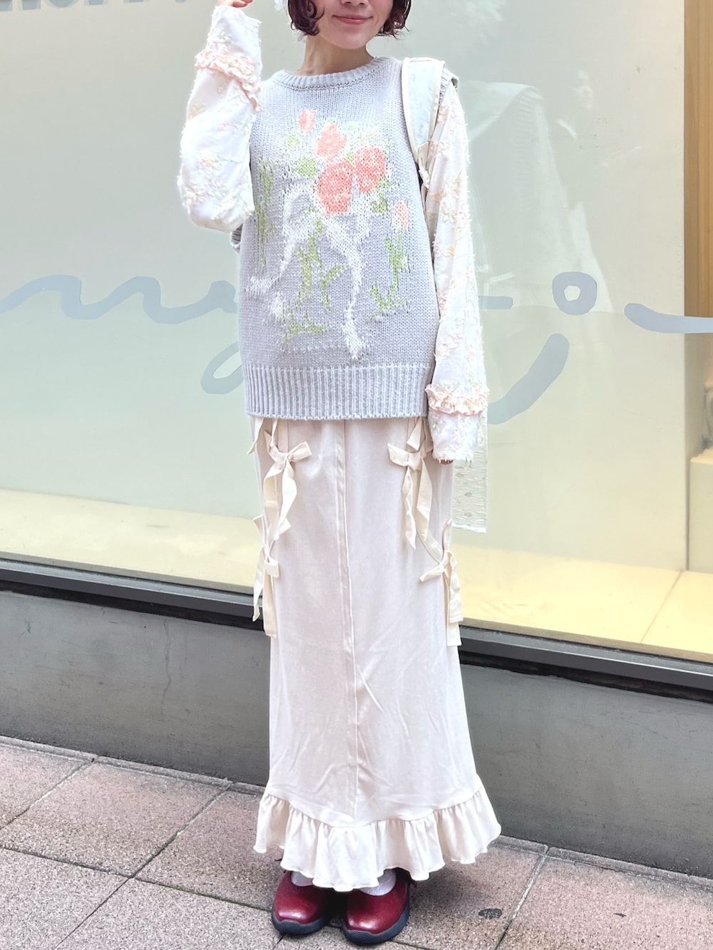 グレー系のベスト、ホワイト系のTシャツ/カットソー、ホワイト系のスカートを着用したレディースの秋コーディネートの2枚目の写真