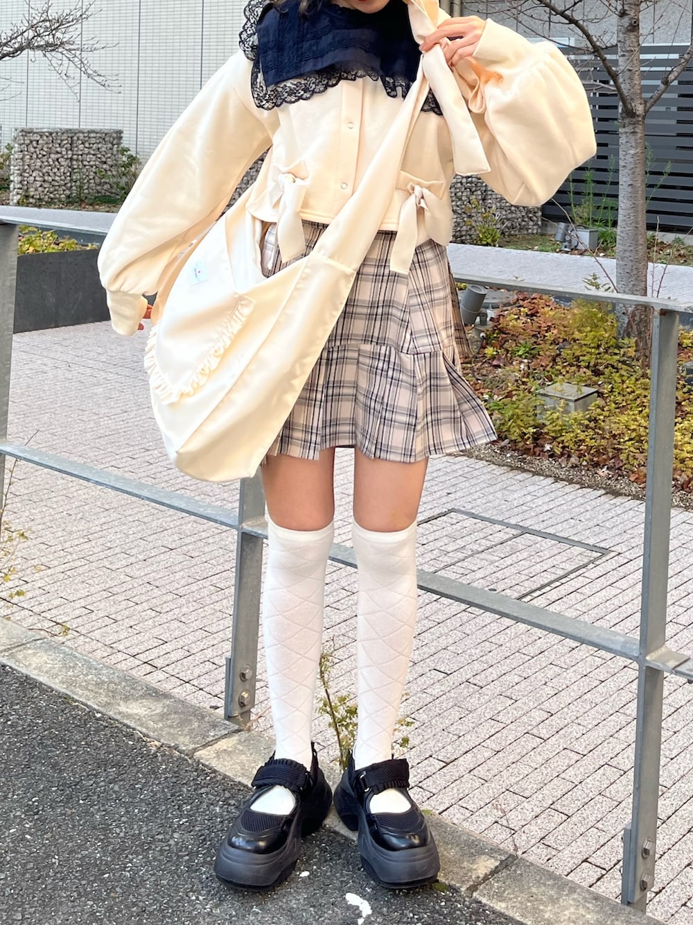 ブルー系のダウンジャケット/コート、ベージュ系のスカート、ホワイト系のトートバッグを着用したレディースの冬コーディネートの3枚目の写真