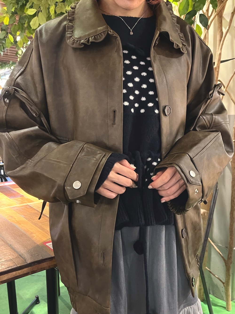 ブラウン系のブルゾン、ブルー系のニット/セーター、グレー系のスカートを着用したレディースの秋コーディネートの8枚目の写真