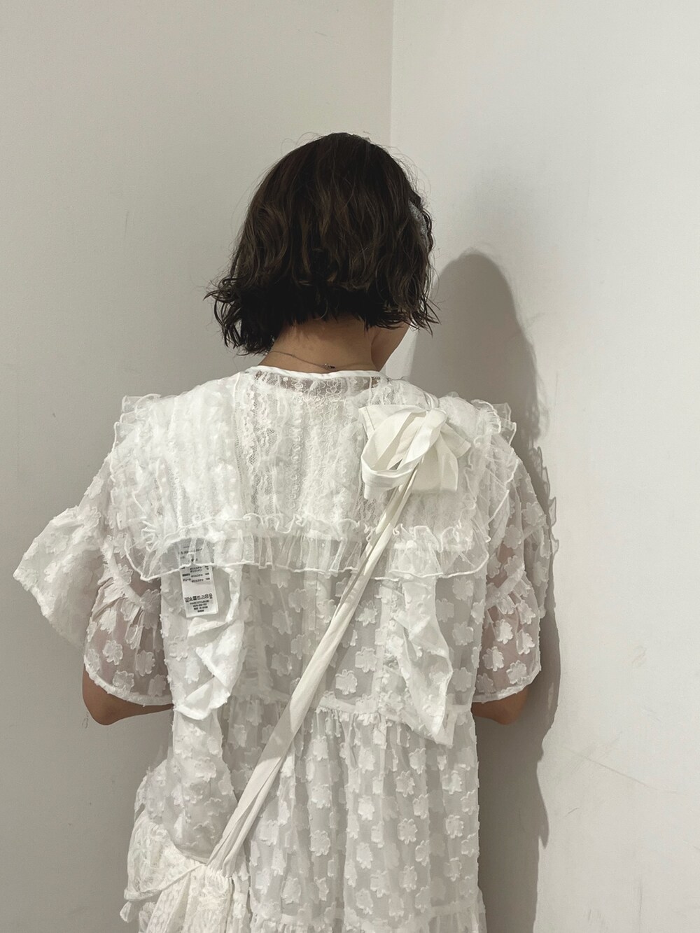 ホワイト系のワンピース、ホワイト系のトートバッグ、ホワイト系のスニーカーを着用したレディースの夏コーディネートの6枚目の写真