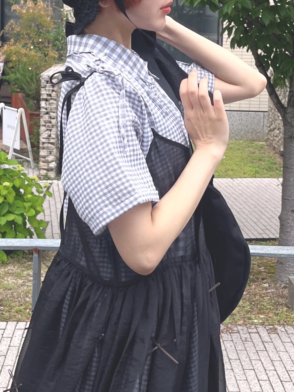 ブラック系のサンダル、ブラック系のトートバッグ、ブラック系のワンピースを着用したレディースの春コーディネートの6枚目の写真