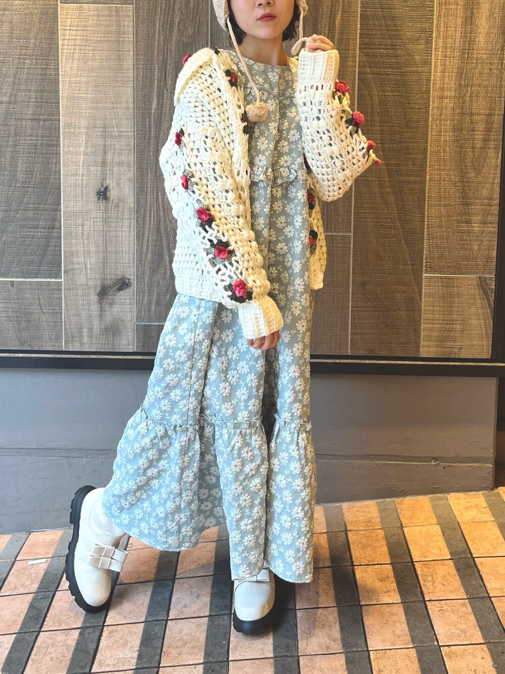 グリーン系のワンピース、ホワイト系のカーディガン/ボレロ、ホワイト系のブーツを着用したレディースの秋コーディネートの2枚目の写真