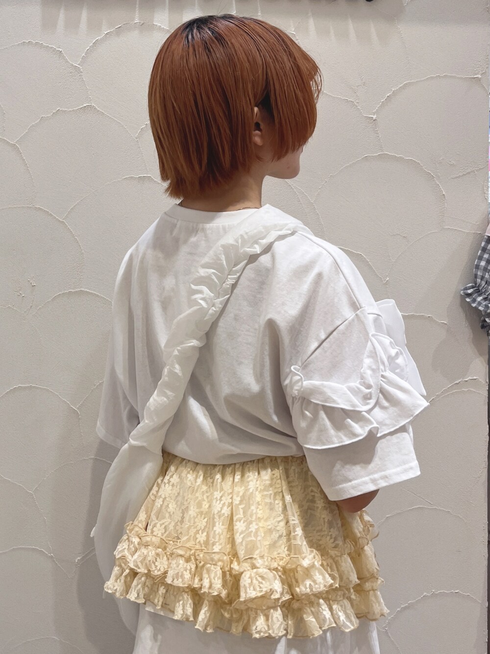 ホワイト系のショルダーバッグ、ホワイト系のTシャツ/カットソー、ブルー系のスラックスを着用したレディースの夏コーディネートの6枚目の写真