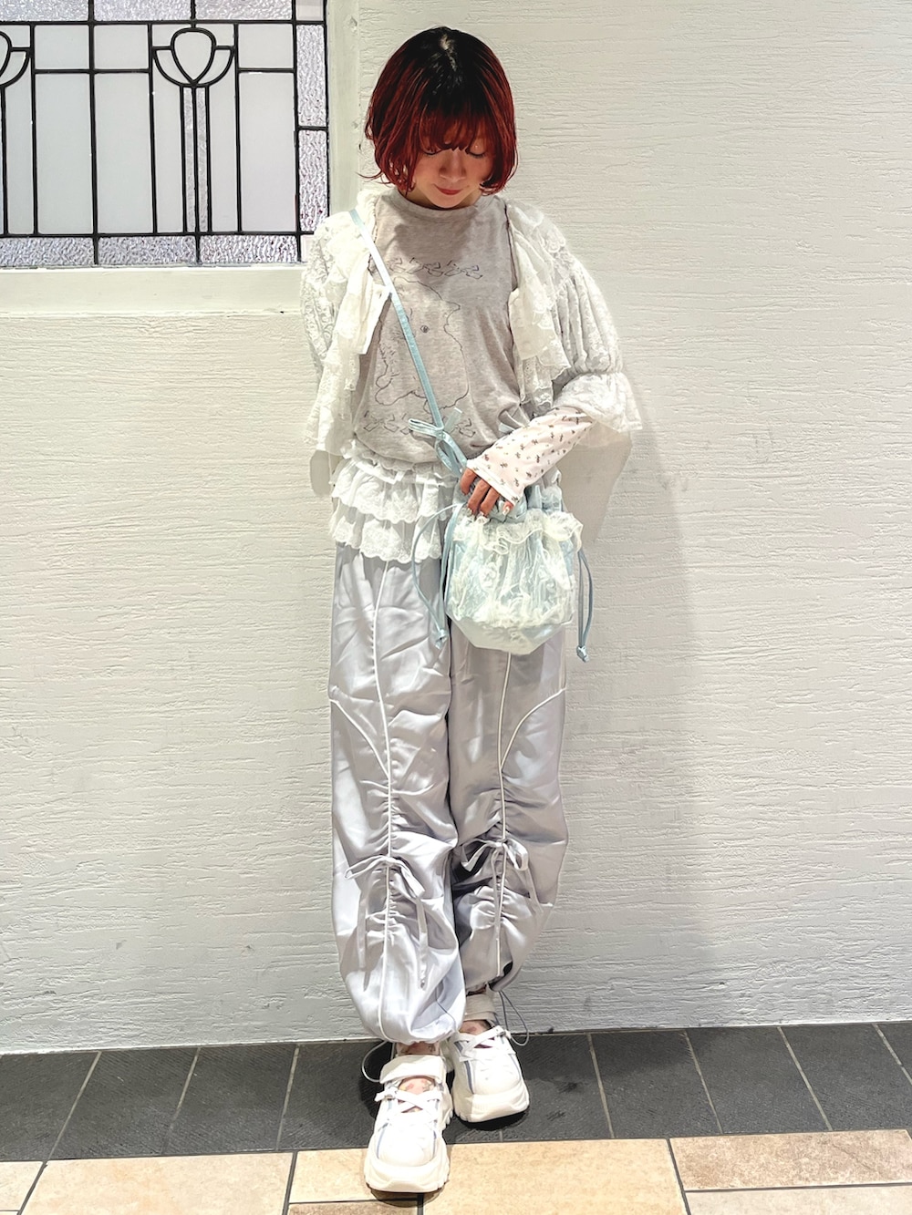 ブルー系のショルダーバッグ、グレー系のTシャツ/カットソー、ホワイト系のカーディガン/ボレロを着用したレディースの秋コーディネートの2枚目の写真