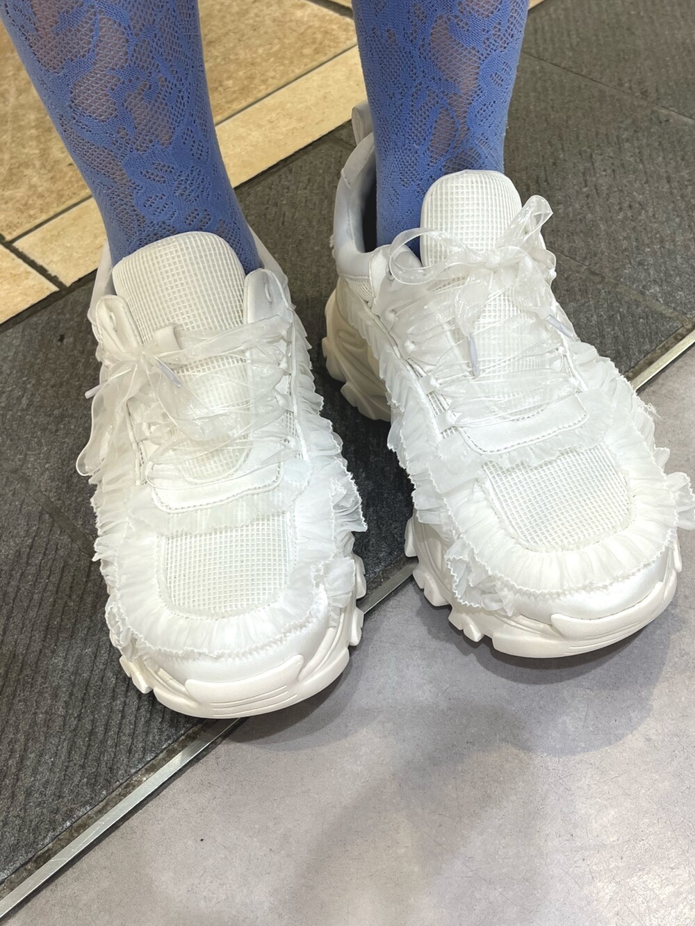 ホワイト系のワンピース、グレー系のタンクトップ、ホワイト系のスニーカーを着用したレディースの春コーディネートの9枚目の写真