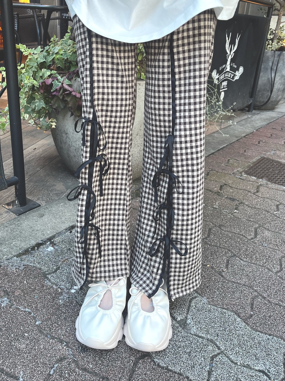 ホワイト系のTシャツ/カットソー、ゴールド系のショルダーバッグ、ブラウン系のスラックスを着用したレディースの夏コーディネートの9枚目の写真