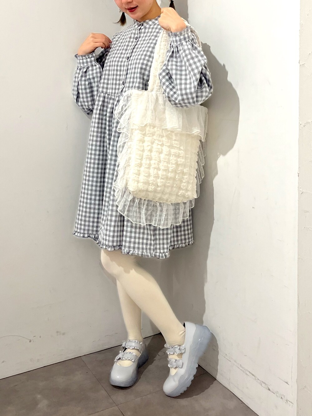 グレー系のワンピース、ホワイト系のトートバッグ、ブルー系のスニーカーを着用したレディースの春コーディネートの7枚目の写真