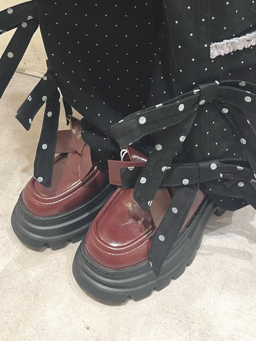 ブラック系のスカート、ブラック系のスラックス、レッド系のローファーを着用したレディースの秋コーディネートの9枚目の写真