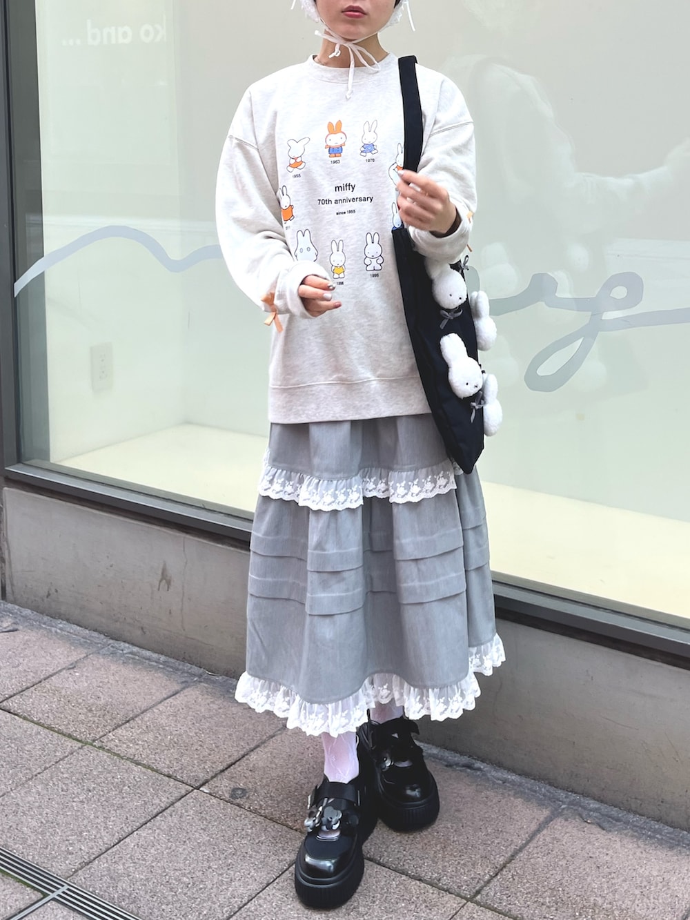 グレー系のスウェット、グレー系のスカート、ブラック系のスニーカーを着用したレディースの冬コーディネートの3枚目の写真