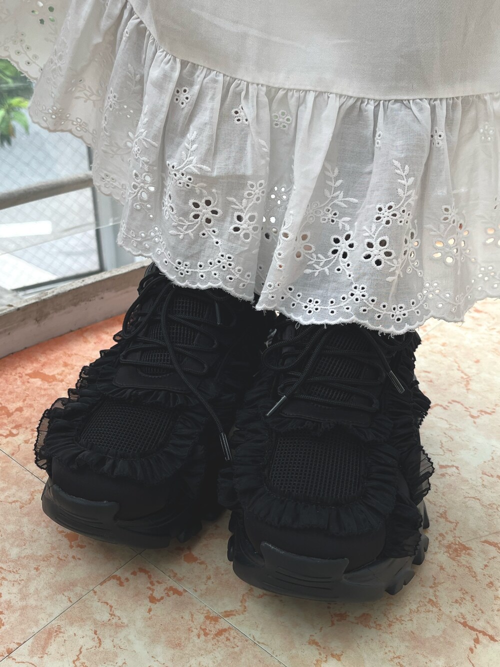 ブラック系のスニーカー、ブラック系のニット/セーター、ホワイト系のワンピースを着用したレディースの春コーディネートの9枚目の写真