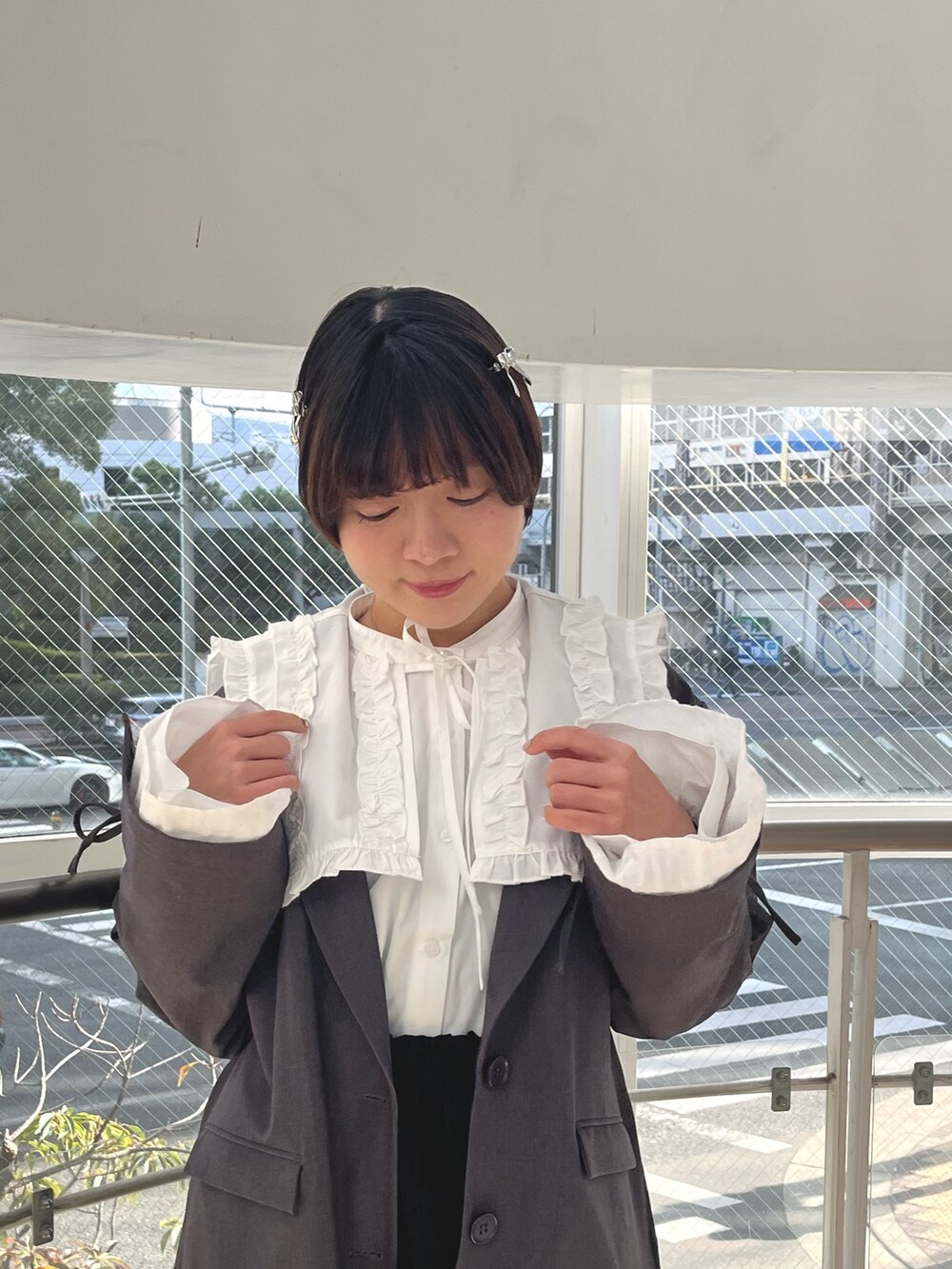 グレー系のテーラードジャケット、ホワイト系のシャツ/ブラウス、ブラック系のスカートを着用したレディースの冬コーディネートの6枚目の写真