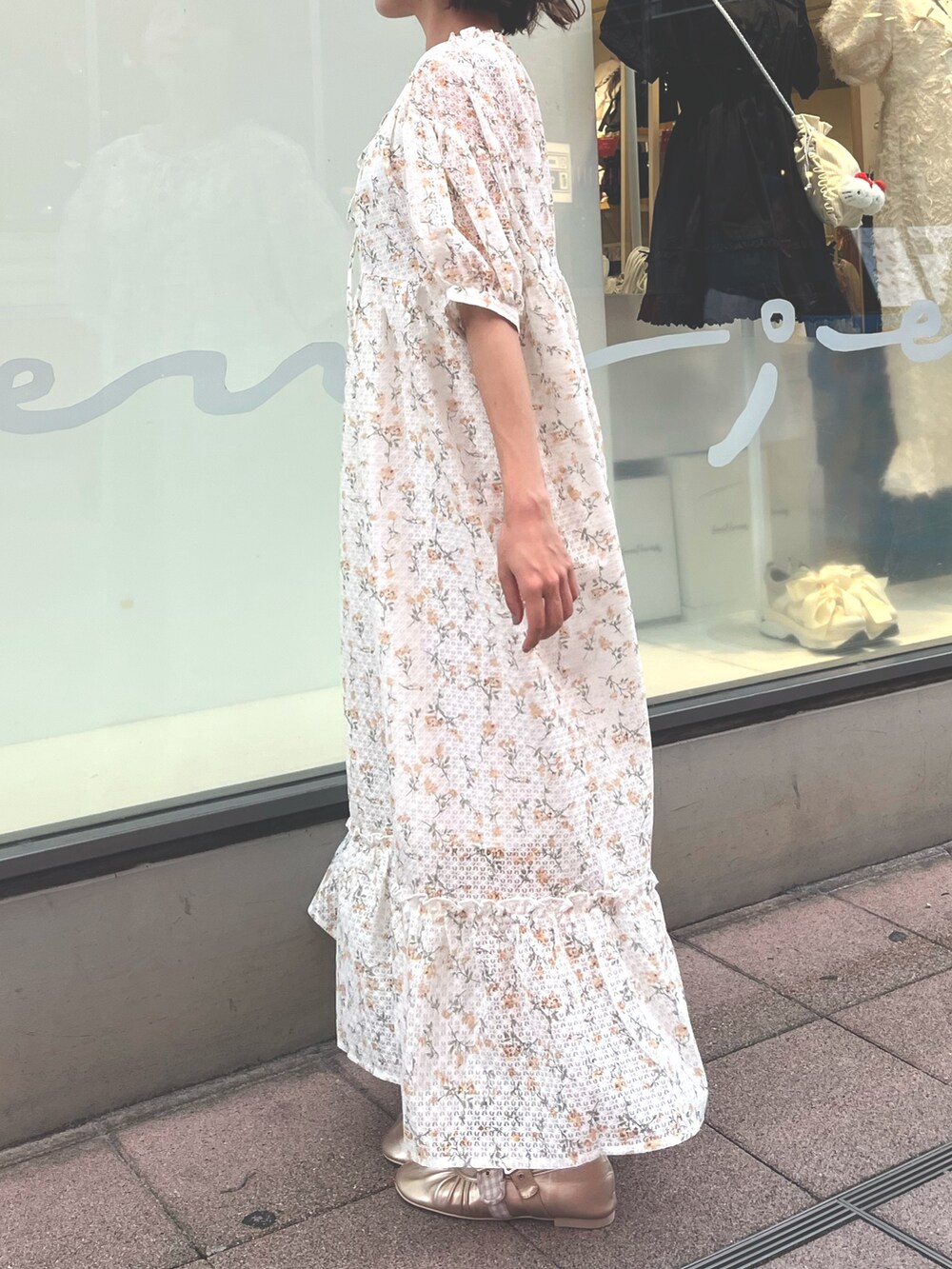 イエロー系のワンピース、ゴールド系のバレエシューズを着用したレディースの夏コーディネートの3枚目の写真