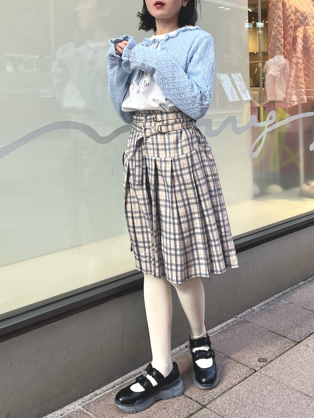 ベージュ系のスカート、ブルー系のカーディガン/ボレロ、ホワイト系のTシャツ/カットソーを着用したレディースの春コーディネートの5枚目の写真