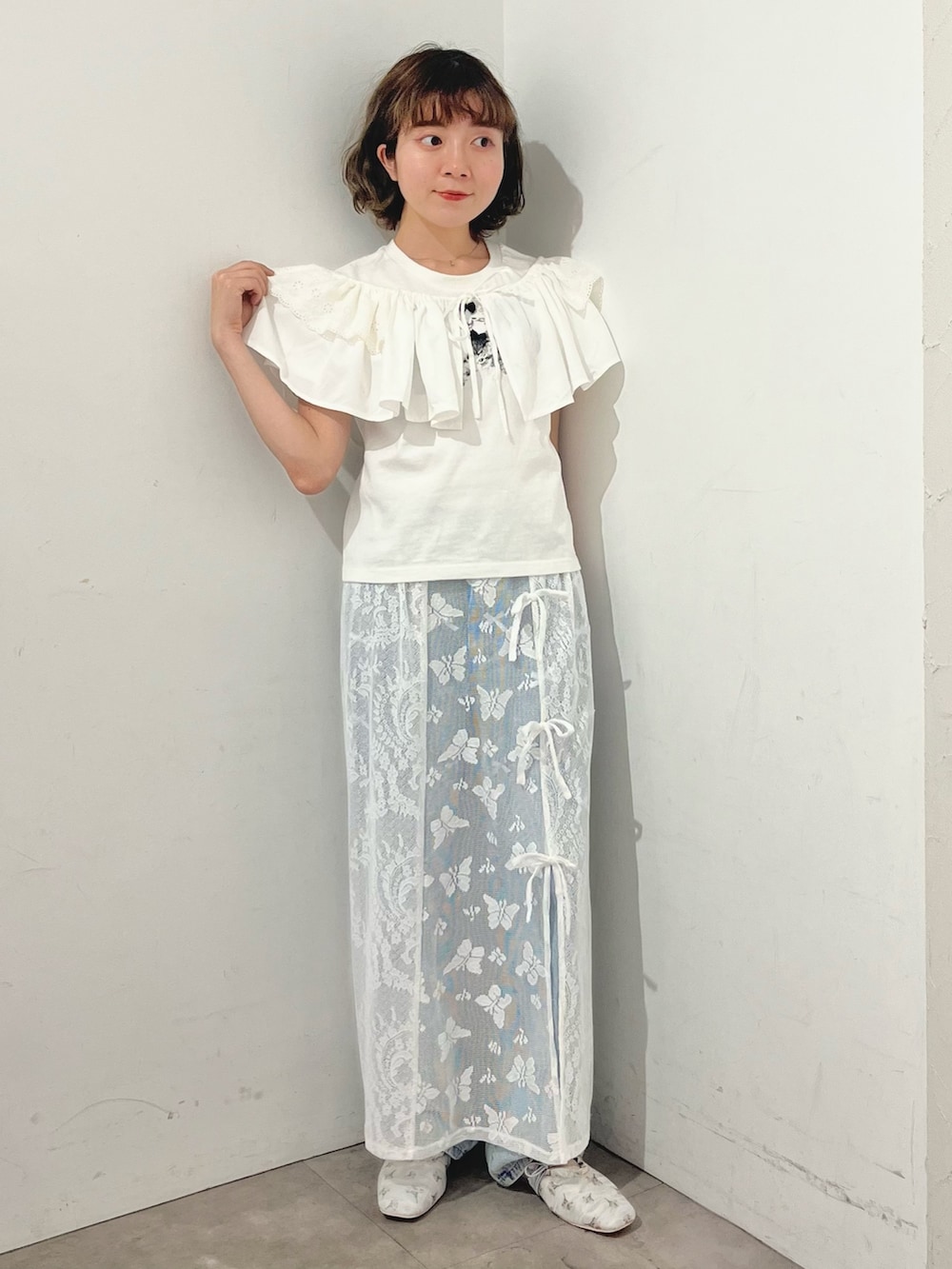 ホワイト系のスカート、ホワイト系のTシャツ/カットソー、ブルー系のデニムパンツを着用したレディースの春コーディネートの6枚目の写真