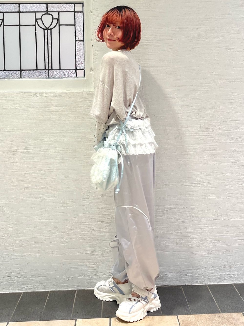 ブルー系のショルダーバッグ、グレー系のTシャツ/カットソー、ホワイト系のカーディガン/ボレロを着用したレディースの秋コーディネートの6枚目の写真