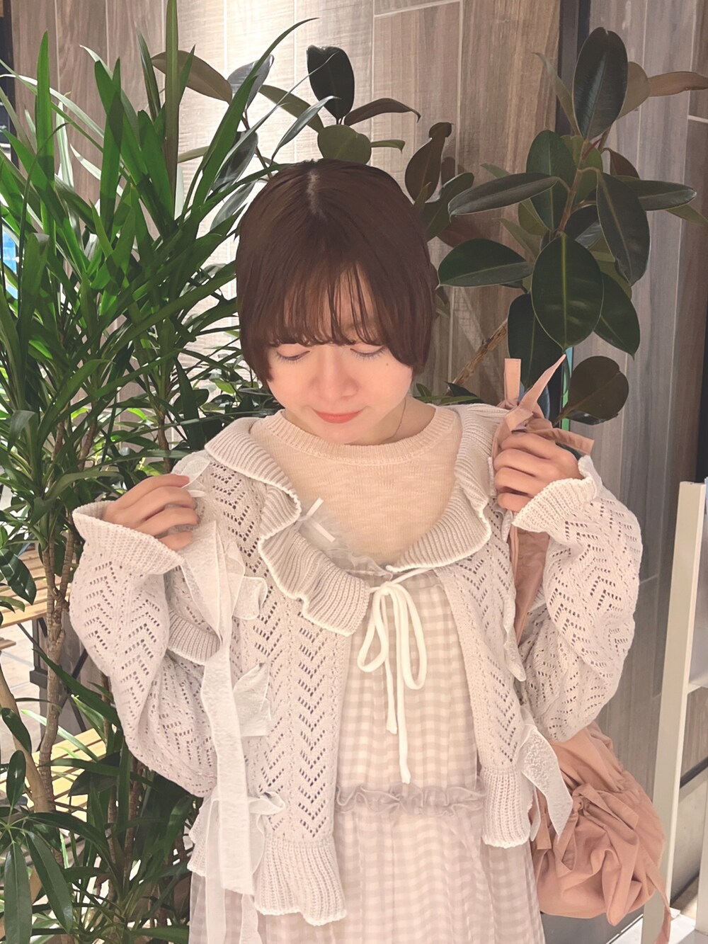 グレー系のカーディガン/ボレロ、ピンク系のニット/セーター、ベージュ系のワンピースを着用したレディースの春コーディネートの5枚目の写真