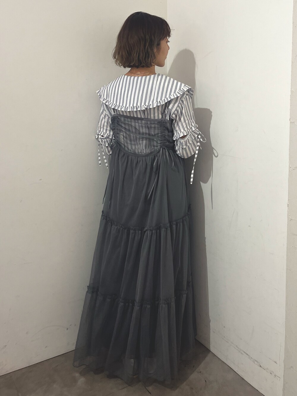 グレー系のワンピース、ホワイト系のシャツ/ブラウス、シルバー系のバレエシューズを着用したレディースの夏コーディネートの3枚目の写真