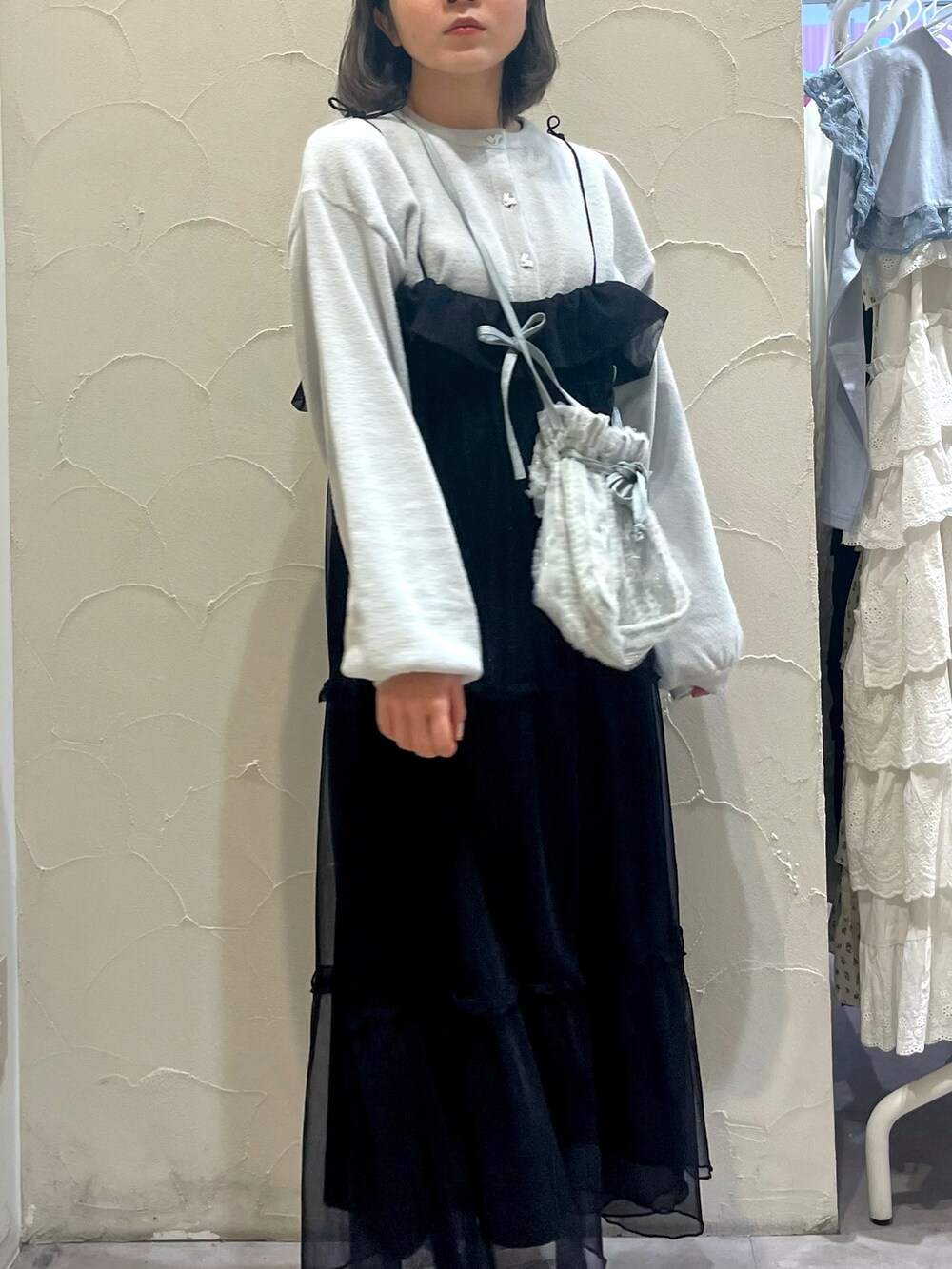 ブラック系のワンピース、ブルー系のショルダーバッグ、ホワイト系のパンプスを着用したレディースの春コーディネートの6枚目の写真