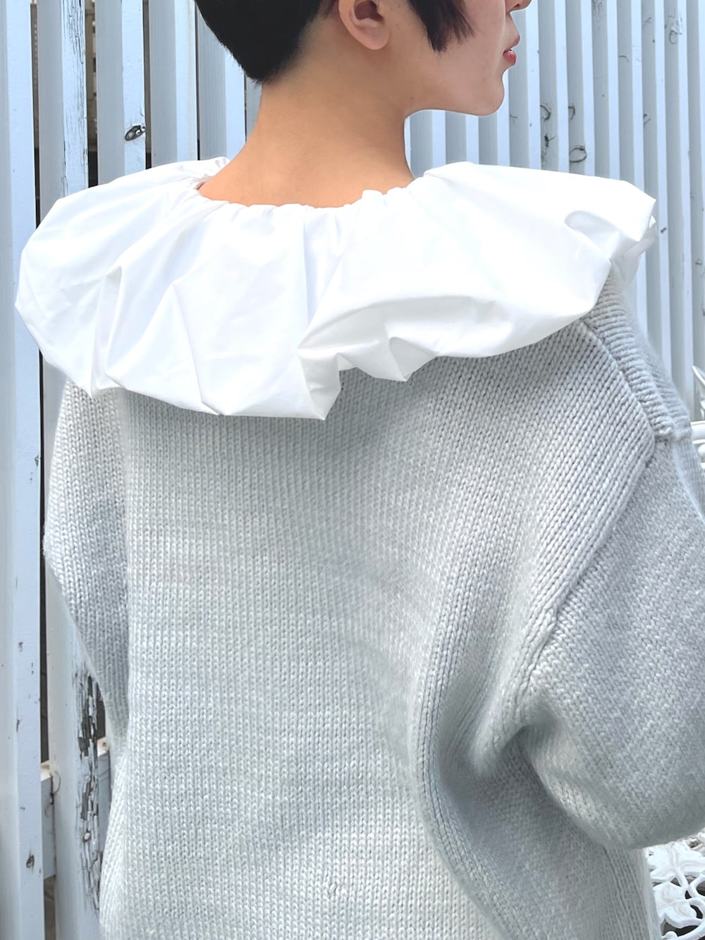 ブラック系のショルダーバッグ、ブルー系のニット/セーター、ホワイト系のシャツ/ブラウスを着用したレディースの冬コーディネートの9枚目の写真