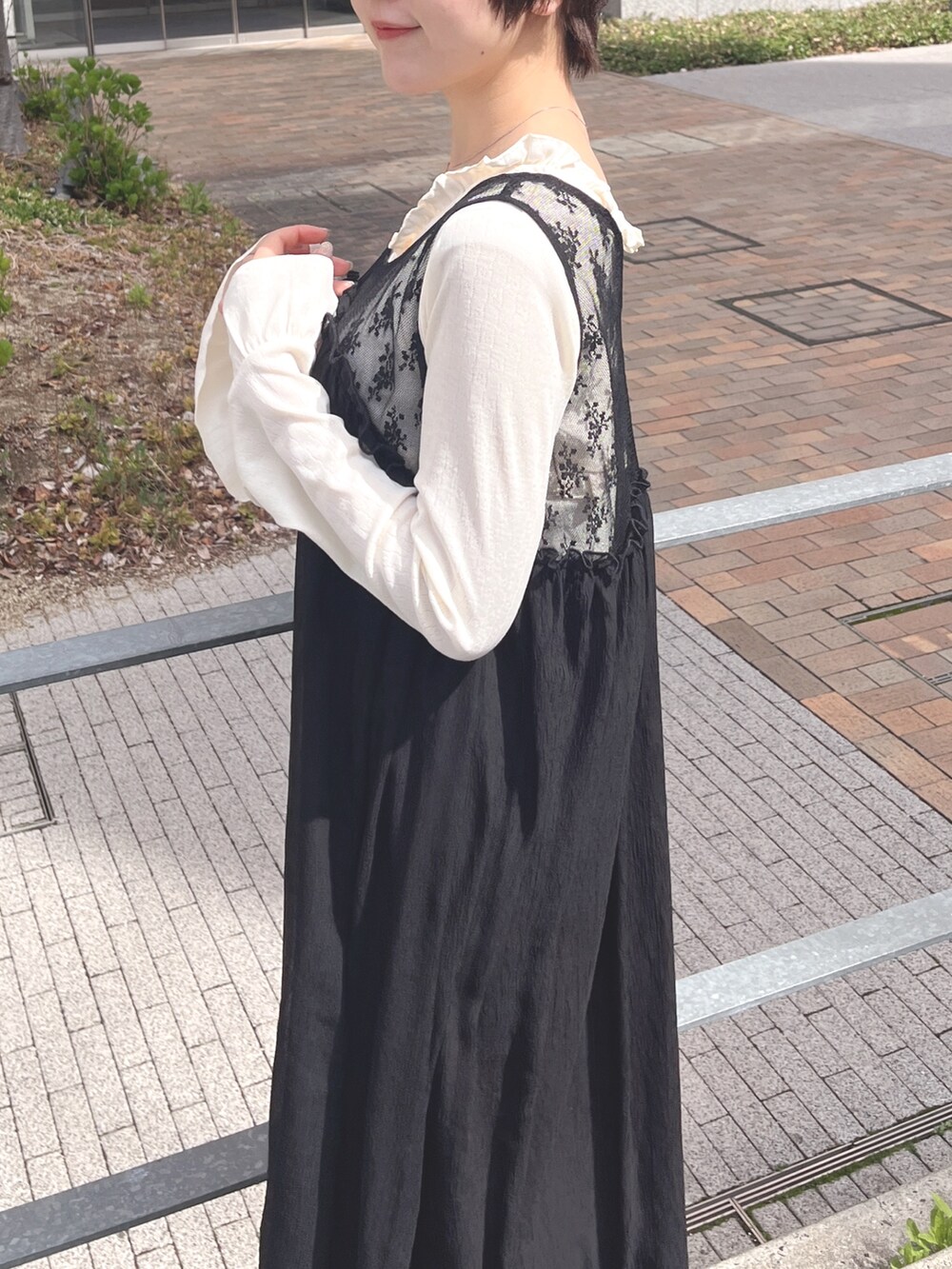 ホワイト系のTシャツ/カットソー、ブラック系のワンピース、ブラック系のスニーカーを着用したレディースの春コーディネートの6枚目の写真