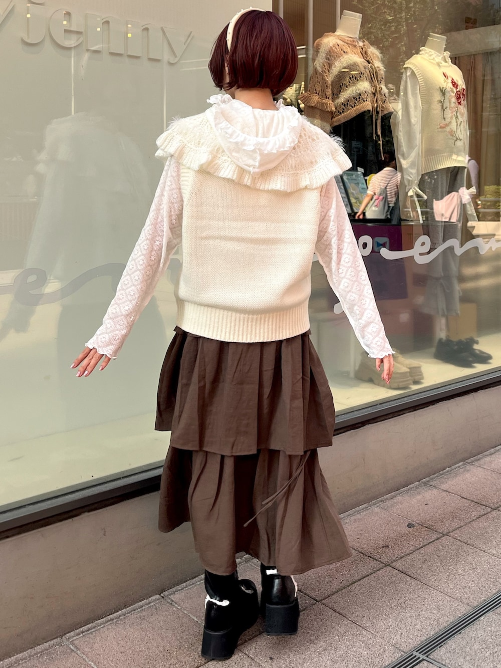 ホワイト系のベスト、ホワイト系のTシャツ/カットソー、ブラウン系のスカートを着用したレディースの秋コーディネートの4枚目の写真