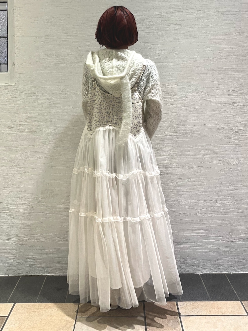 ピンク系のボストンバッグ、ホワイト系のニット/セーター、ホワイト系のワンピースを着用したレディースの秋コーディネートの4枚目の写真