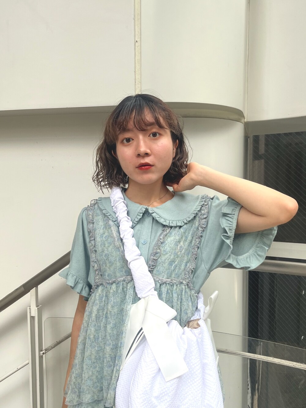 ホワイト系のショルダーバッグ、ブルー系のワンピース、グリーン系のワンピースを着用したレディースの夏コーディネートの6枚目の写真