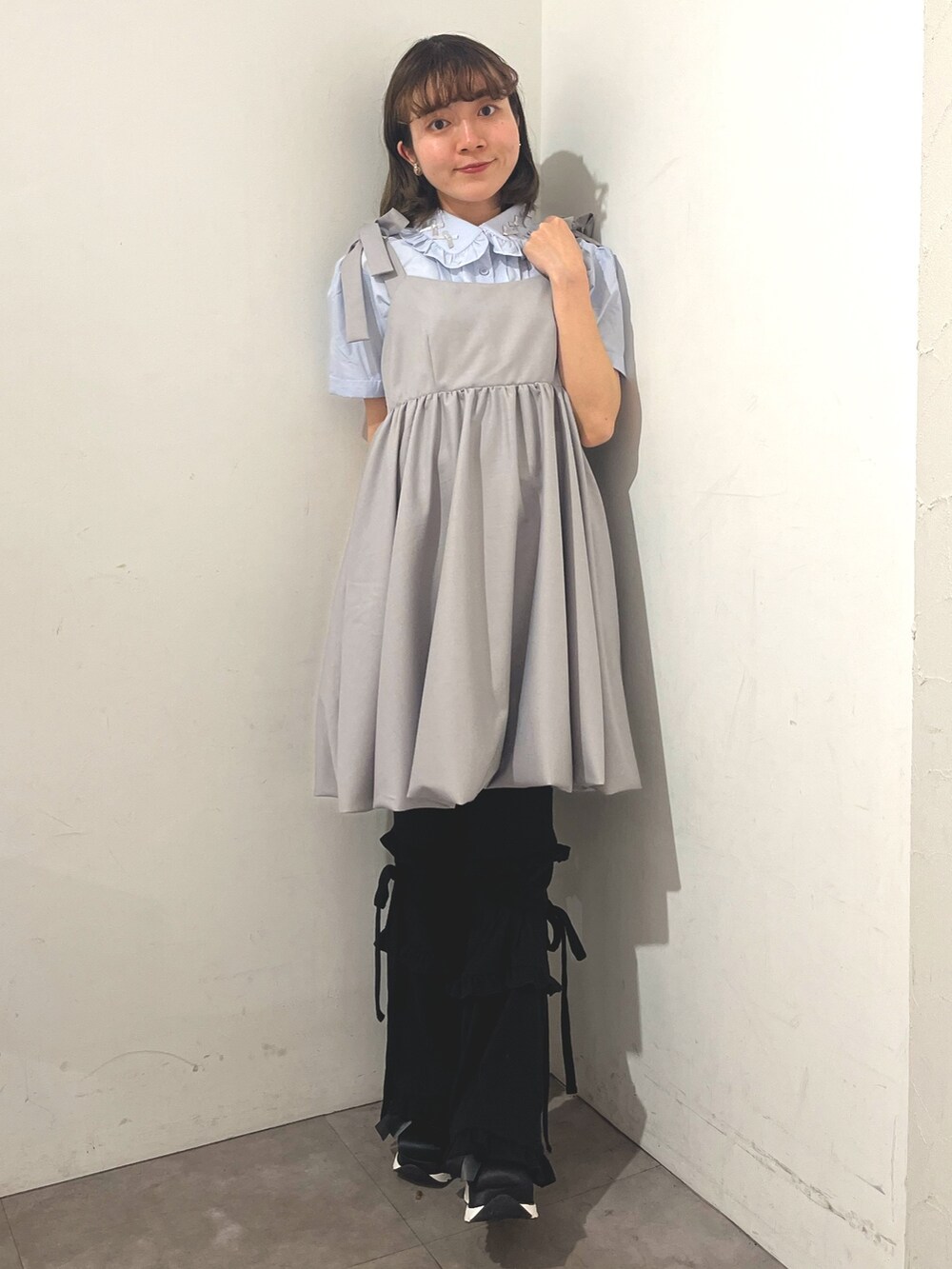 グレー系のワンピース、ブルー系のシャツ/ブラウス、ブラック系のスウェットパンツを着用したレディースの春コーディネートの2枚目の写真