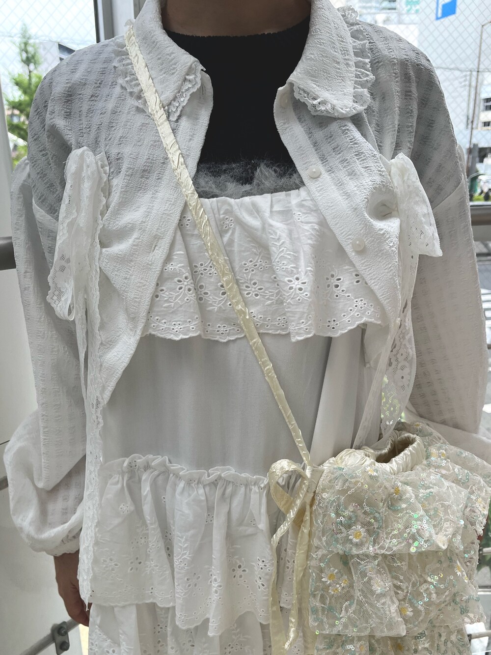 ブラック系のスニーカー、ブラック系のニット/セーター、ホワイト系のワンピースを着用したレディースの春コーディネートの7枚目の写真