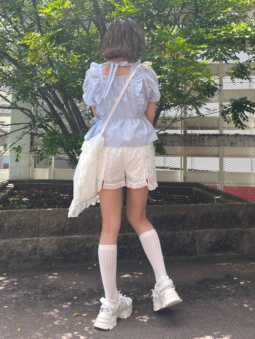 ブルー系のシャツ/ブラウス、ホワイト系のチノパンツ、ホワイト系のスニーカーを着用したレディースの夏コーディネートの4枚目の写真