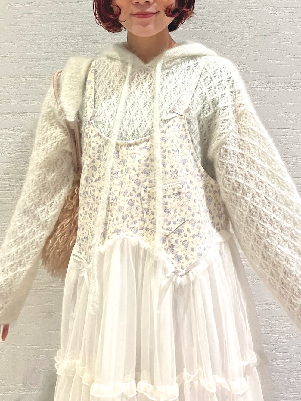 ピンク系のボストンバッグ、ホワイト系のニット/セーター、ホワイト系のワンピースを着用したレディースの秋コーディネートの7枚目の写真