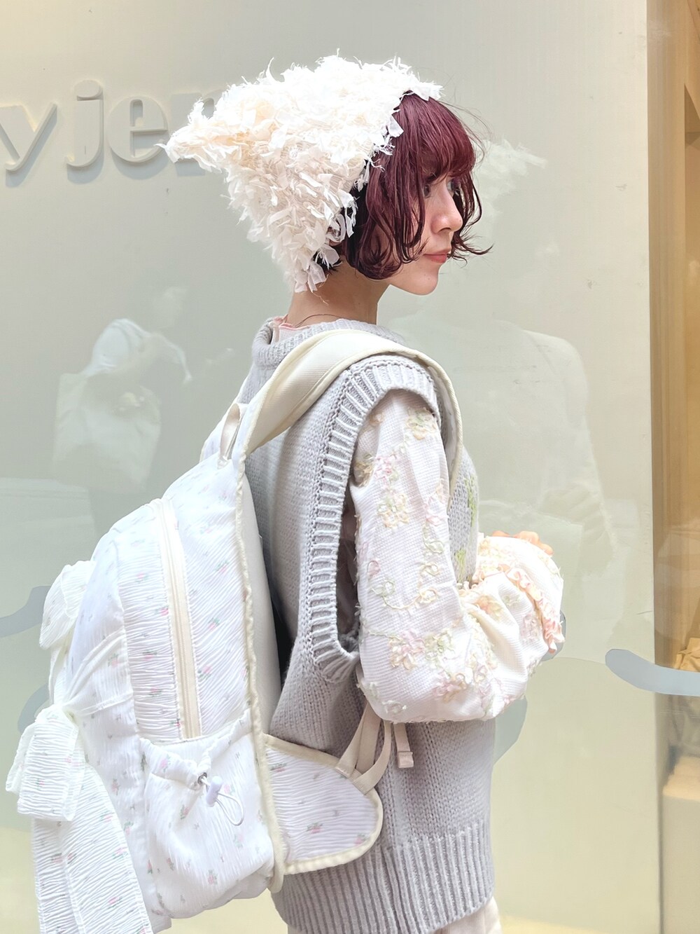 グレー系のベスト、ホワイト系のTシャツ/カットソー、ホワイト系のスカートを着用したレディースの秋コーディネートの6枚目の写真